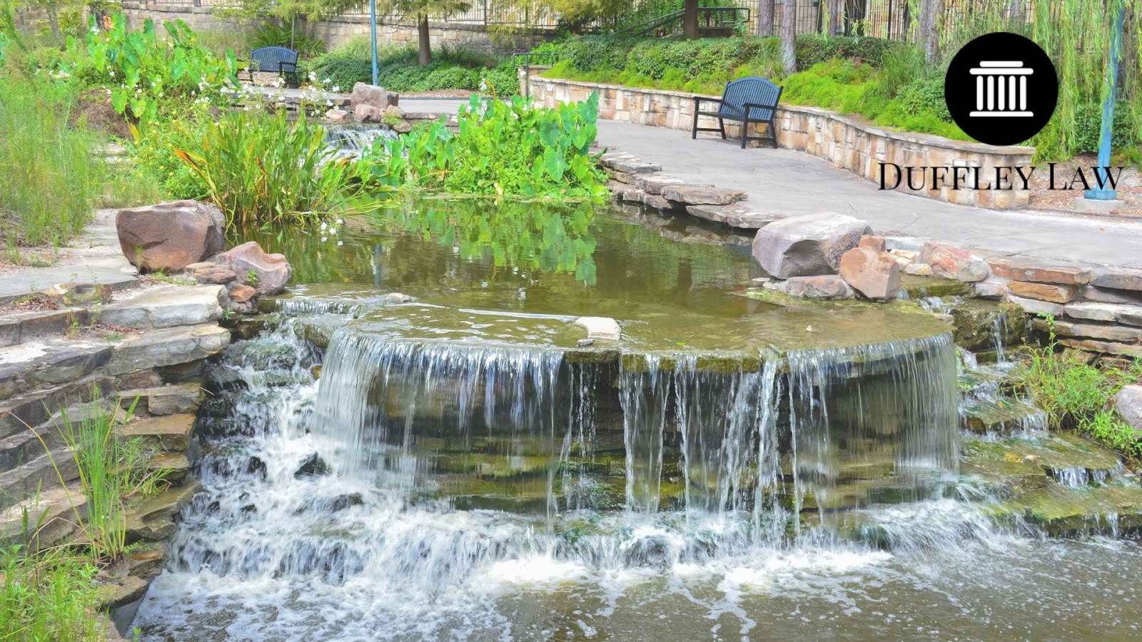 Small waterfall in a landscaped garden pond in woodlands texas.