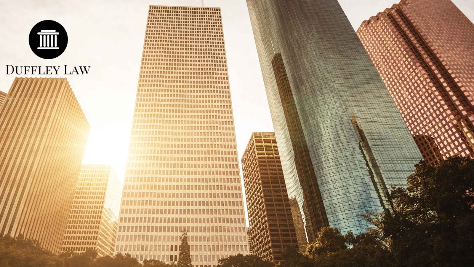 Sunlit Houston skyscrapers with Duffley Law logo