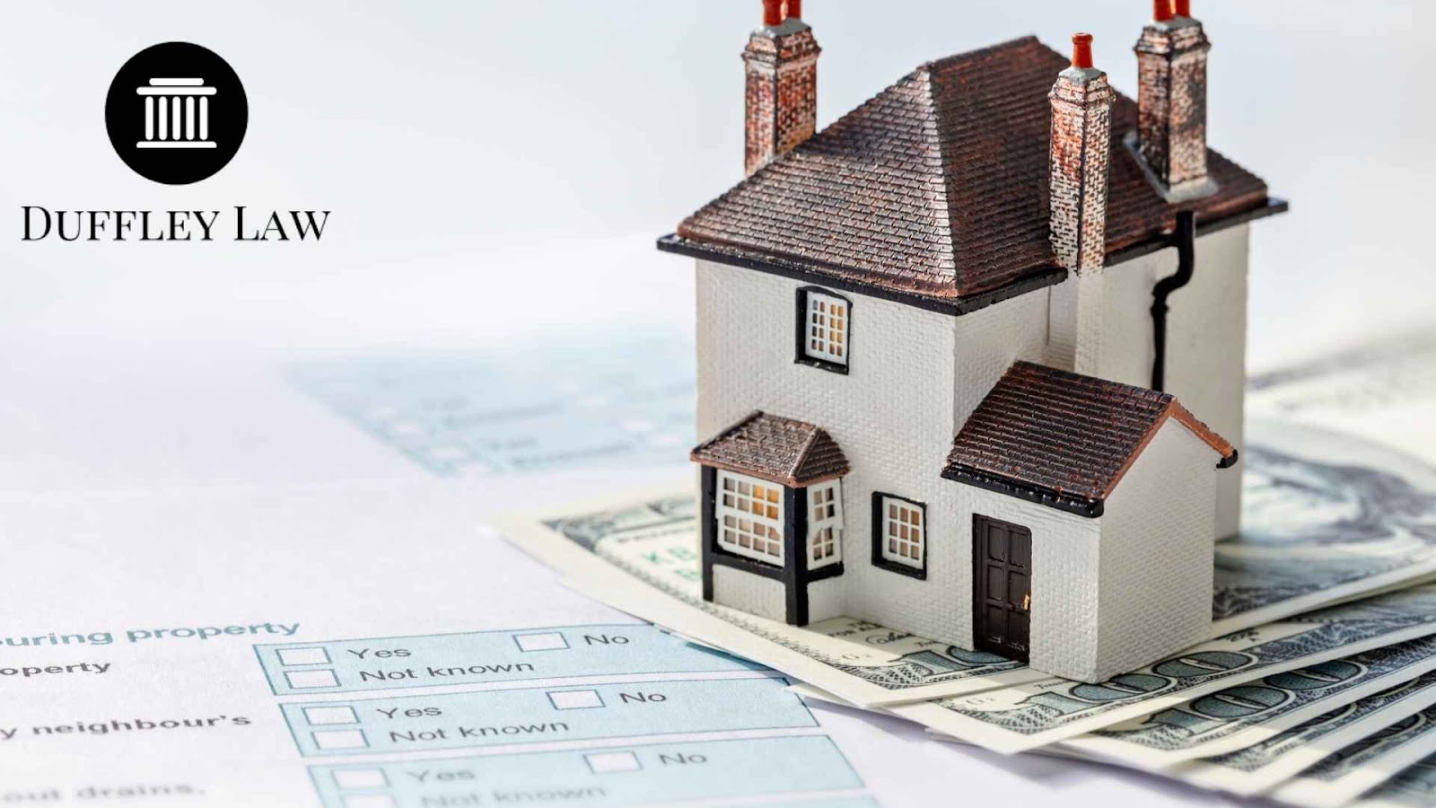 Miniature house on top of dollar bills adn estate planning papers