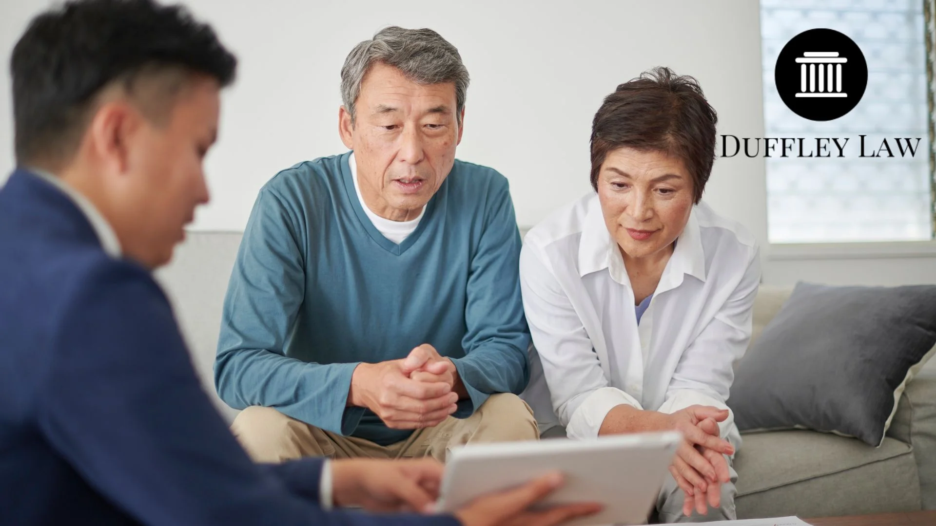 Elderly couple meeting lawyer reviewing tablet