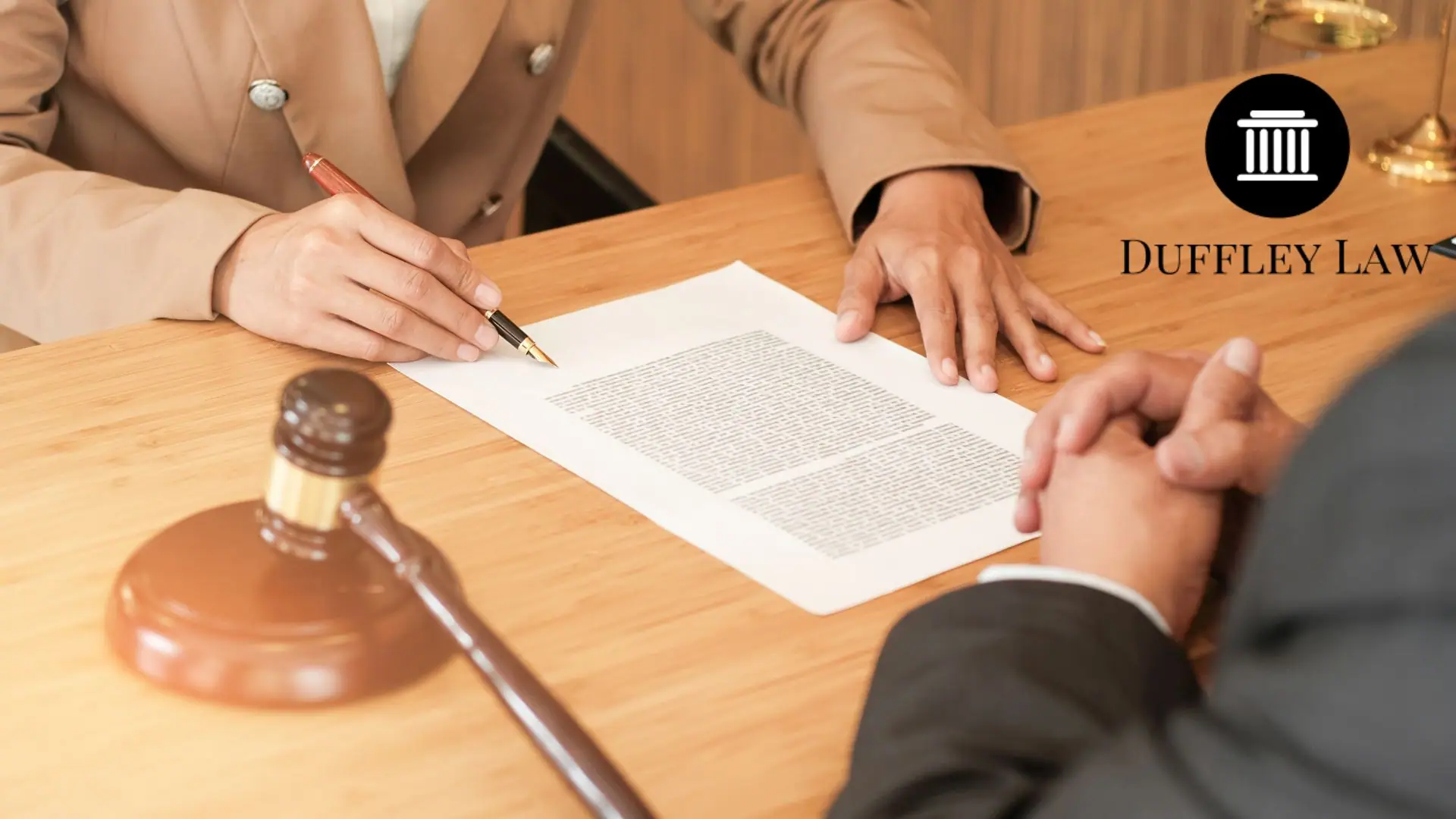 Lawyer signing legal document with gavel nearby