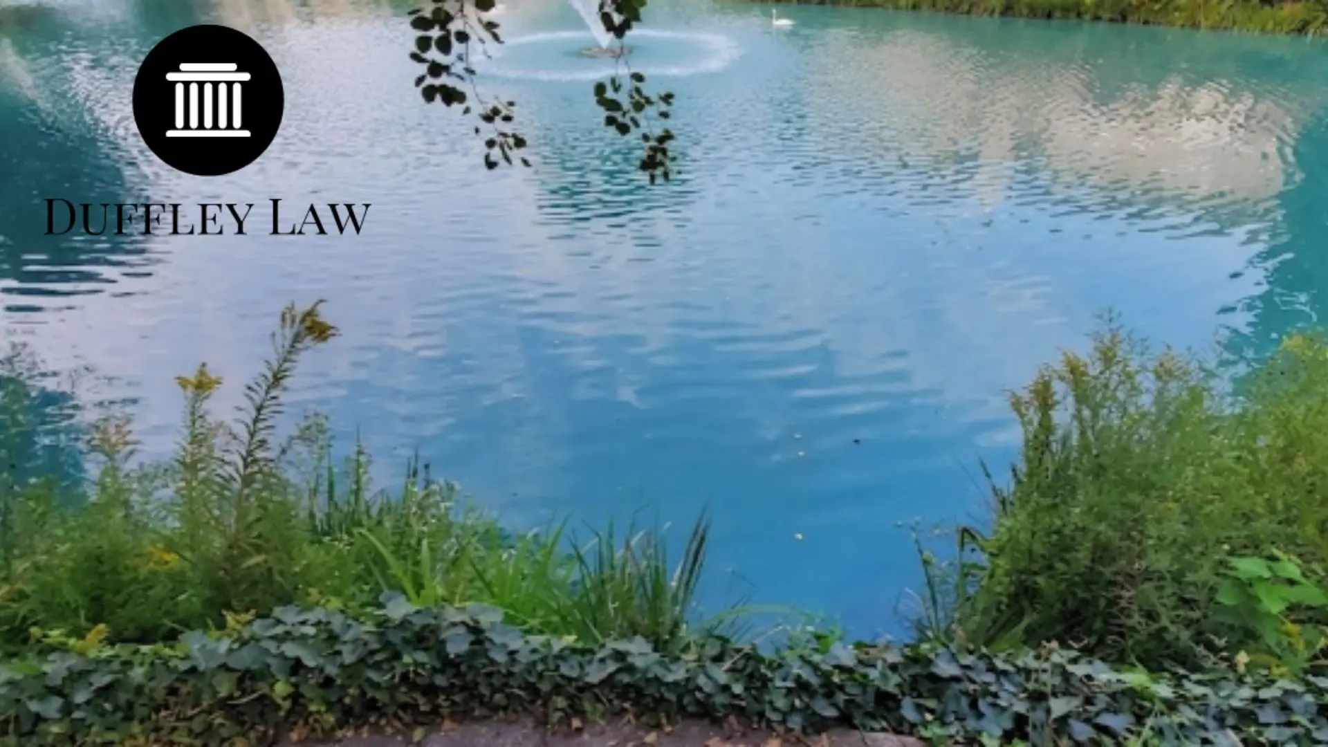 Blue pond with fountain and Duffley Law logo