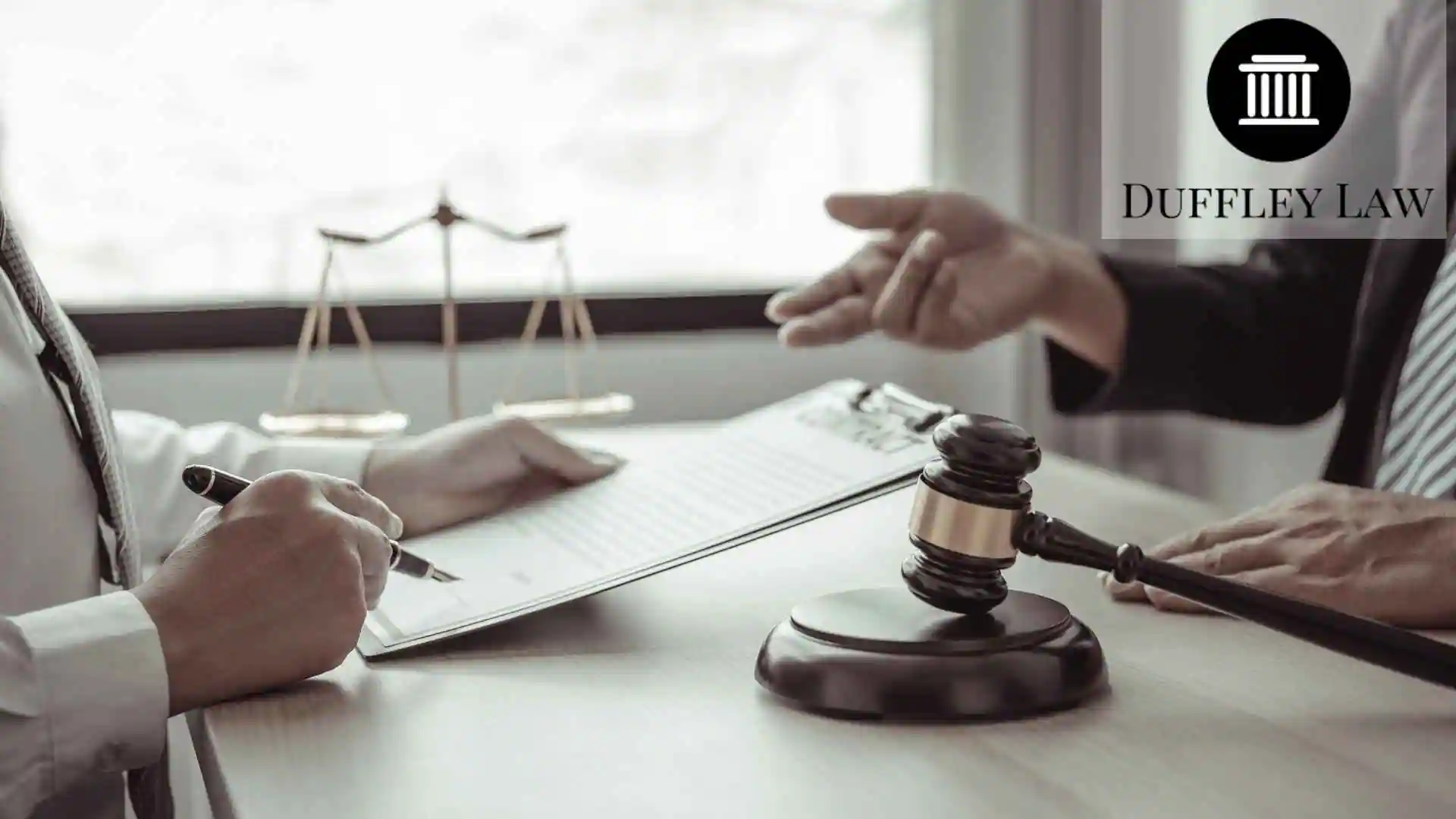 Lawyers discussing documents beside gavel and justice scales